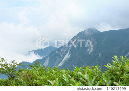 A magnificent view of the rugged ridgeline of the north face and the rising sea of white clouds from near the sixth station of Mt. Daisen (Daisen Town, Tottori Prefecture). A magnificent view of the rugged ridgeline of the north face and the rising sea of white clouds from near the sixth station of Mt. Daisen (Daisen Town, Tottori Prefecture). 140215699