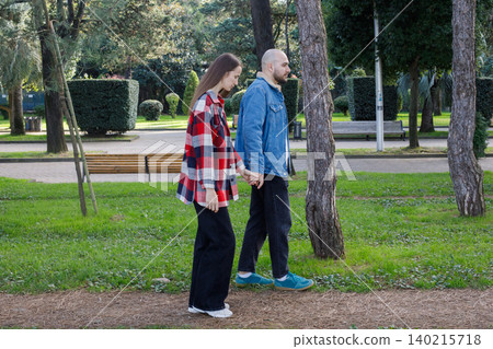 Cute couple walking together outdoors in city park 140215718