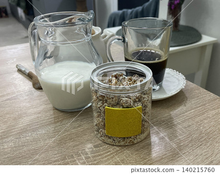a table with a jar of nuts and a glass of milk a table with a jar of nuts and a glass of milk 140215760