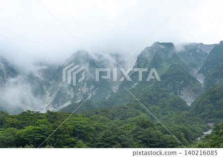 從大山和魚座谷附近眺望,可以看到籠罩在濃霧中的崎嶇山坡和眼前綿延的茂密夏季森林(鳥取縣)。 從大山和魚座谷附近眺望,可以看到籠罩在濃霧中的崎嶇山坡和眼前綿延的茂密夏季森林(鳥取縣)。 140216085