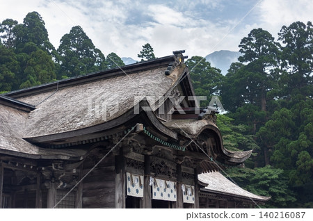 The dignified wooden shrine building of the Okumiya (inner sanctuary) of Ogamiyama Shrine, with the ridge of Mt. Daisen towering in the background (Daisen Town, Tottori Prefecture). The dignified wooden shrine building of the Okumiya (inner sanctuary) of Ogamiyama Shrine, with the ridge of Mt. Daisen towering in the background (Daisen Town, Tottori Prefecture). 140216087
