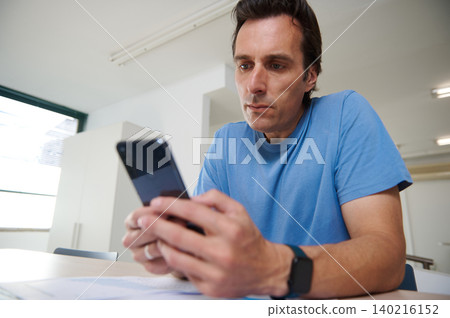 Man  focused on work, analyzing charts while working on laptop in co-working office 140216152