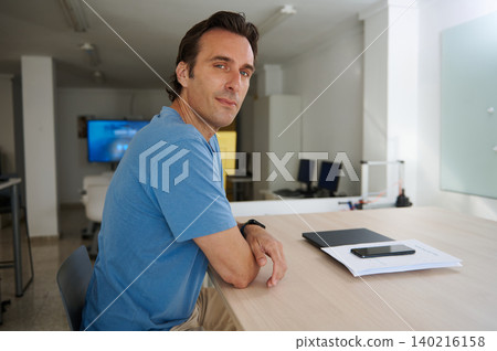 Man focused on work, analyzing charts while working on laptop in co-working office Man focused on work, analyzing charts while working on laptop in co-working office 140216158