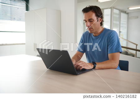 Man working on laptop in bright office space, focused remote work and productivity Man working on laptop in bright office space, focused remote work and productivity 140216182