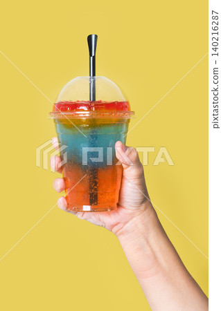 Person holding a colorful layered slushie drink Person holding a colorful layered slushie drink 140216287