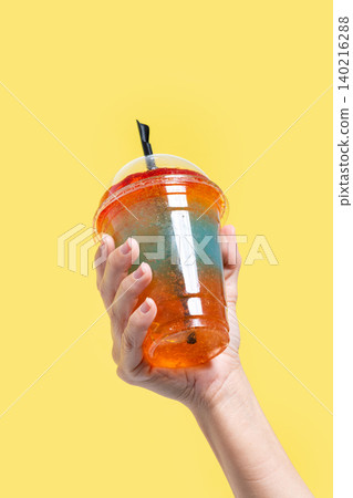 Person holding a colorful layered slushie drink Person holding a colorful layered slushie drink 140216288