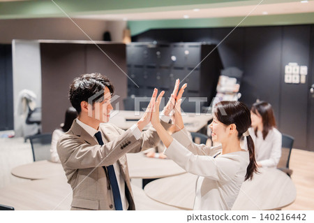 The office team high-fives each other after a great success. The office team high-fives each other after a great success. 140216442