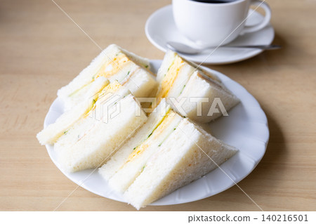 A delicious mixed sandwich and coffee from a coffee shop. A delicious mixed sandwich and coffee from a coffee shop. 140216501