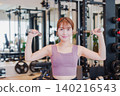 A young woman doing dumbbell training at the gym 140216543