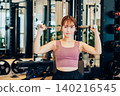 A young woman doing dumbbell training at the gym 140216545