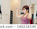 A young woman doing dumbbell training at the gym 140216546
