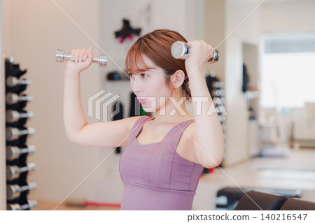 A young woman doing dumbbell training at the gym A young woman doing dumbbell training at the gym 140216547