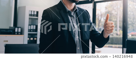 Smiling businessman in suit works on laptop in bright modern office 140216948