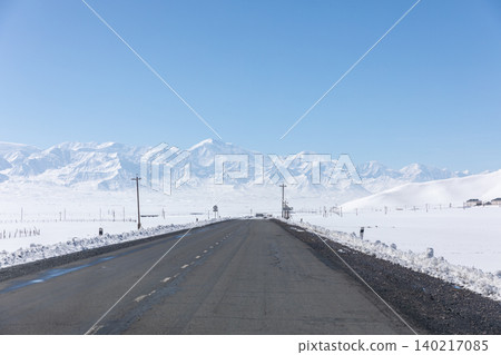 Empty winter highway through Alay Valley with snowy mountains, Kyrgyzstan Empty winter highway through Alay Valley with snowy mountains, Kyrgyzstan 140217085