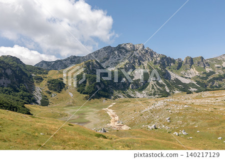 Mountain valley landscape with rocky peaks and meadow in Durmitor National Park 140217129