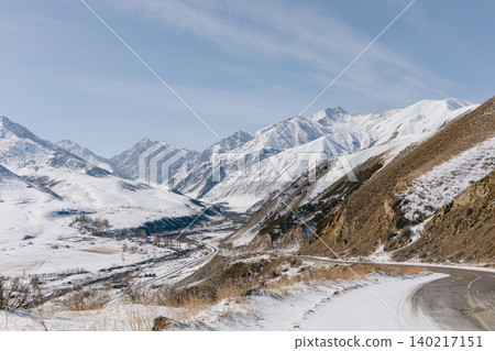 Scenic mountain road through snowy Tien Shan valley landscape in Kyrgyzstan Scenic mountain road through snowy Tien Shan valley landscape in Kyrgyzstan 140217151