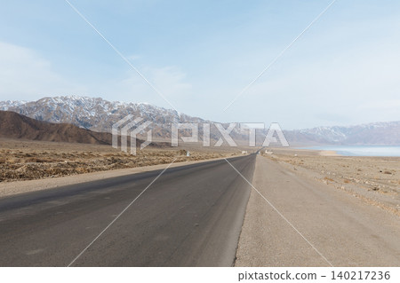 Empty highway along Issyk-Kul Lake with Tian Shan mountains, Kyrgyzstan Empty highway along Issyk-Kul Lake with Tian Shan mountains, Kyrgyzstan 140217236