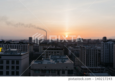 Bishkek city skyline at sunset with industrial smokestacks and haze pollution Bishkek city skyline at sunset with industrial smokestacks and haze pollution 140217243