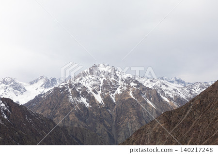 Snowy mountain peaks and rugged ridges at Too Ashuu Pass in Kyrgyzstan Snowy mountain peaks and rugged ridges at Too Ashuu Pass in Kyrgyzstan 140217248
