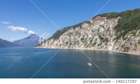 Vilyuchinskaya Bay coastline with distant volcano and sailboat, Kamchatka Vilyuchinskaya Bay coastline with distant volcano and sailboat, Kamchatka 140217297