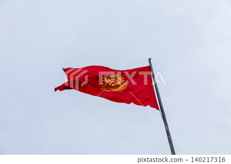 Kyrgyzstan national flag waving on flagpole against cloudy sky background Kyrgyzstan national flag waving on flagpole against cloudy sky background 140217316