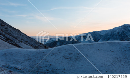 Winter sunrise over Chunkurchak Valley mountains with snow and pastel sky 140217339