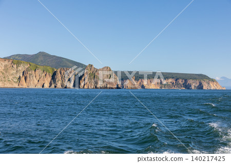 Rocky sea cliffs and coastal mountains on Kamchatka Peninsula, Russia in summer Rocky sea cliffs and coastal mountains on Kamchatka Peninsula, Russia in summer 140217425