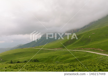 Misty mountain slopes and winding road near Aktoprak village in the Caucasus 140217449