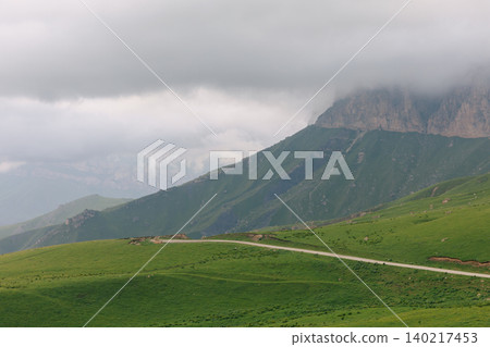 Scenic mountain road and green alpine meadow near Aktoprak pass, Caucasus 140217453