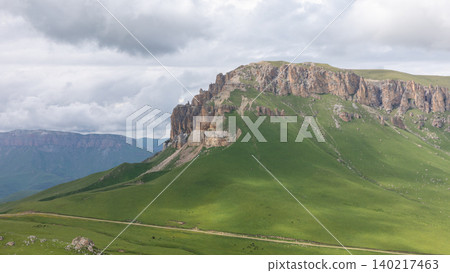 View from Mount Naudzhidza plateau with green slopes and cliffs in Caucasus landscape View from Mount Naudzhidza plateau with green slopes and cliffs in Caucasus landscape 140217463
