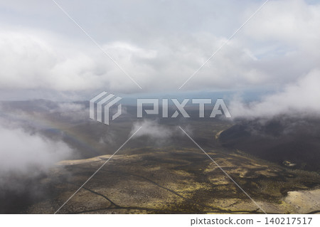 Tolbachinsky Dol volcanic plateau landscape with low clouds and rainbow, Kamchatka Tolbachinsky Dol volcanic plateau landscape with low clouds and rainbow, Kamchatka 140217517