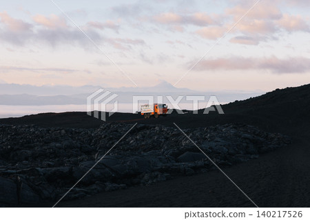 Off-road truck on volcanic landscape in Tolbachinsky Dol, Kamchatka at sunrise Off-road truck on volcanic landscape in Tolbachinsky Dol, Kamchatka at sunrise 140217526