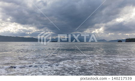 Stormy seascape with sun rays over Avacha Bay coastline in Kamchatka Peninsula 140217539