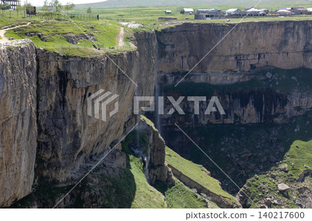 Itlyatlyar waterfall cascading into a deep canyon on a sunny mountain plateau Itlyatlyar waterfall cascading into a deep canyon on a sunny mountain plateau 140217600