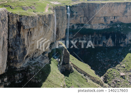 Itlyatlyar waterfall plunging into deep canyon with cliffs and green plateau Itlyatlyar waterfall plunging into deep canyon with cliffs and green plateau 140217603