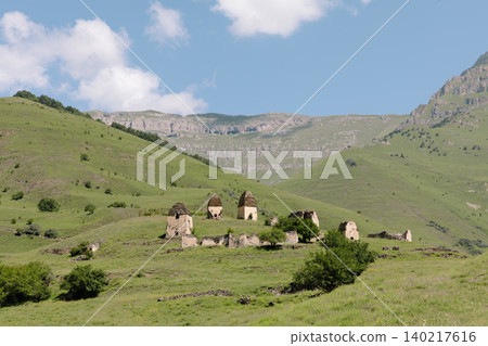 Erzi tower complex ruins in the Caucasus Mountains landscape under blue sky 140217616