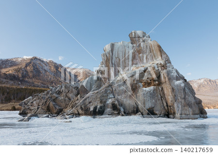 Rocky cliff and frozen shoreline on Lake Baikal under clear winter sky Rocky cliff and frozen shoreline on Lake Baikal under clear winter sky 140217659