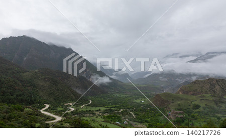 Misty mountain valley with winding road in Dagestan, Caucasus landscape view Misty mountain valley with winding road in Dagestan, Caucasus landscape view 140217726
