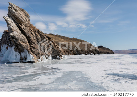 Winter ice and rocky shoreline landscape on Lake Baikal under blue sky Winter ice and rocky shoreline landscape on Lake Baikal under blue sky 140217770