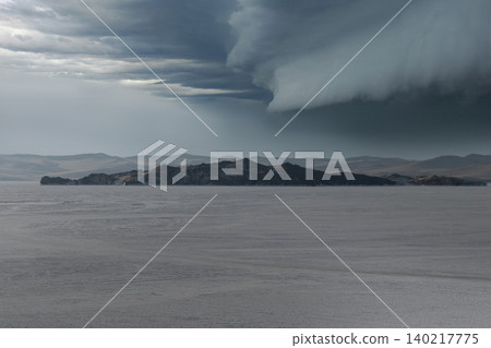 Storm clouds over Lake Baikal with distant island and frozen winter landscape Storm clouds over Lake Baikal with distant island and frozen winter landscape 140217775