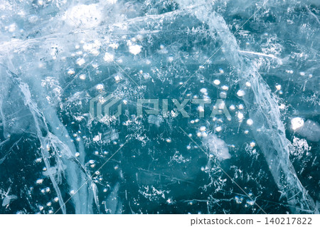 Abstract blue ice texture with frozen air bubbles and cracks, winter background Abstract blue ice texture with frozen air bubbles and cracks, winter background 140217822