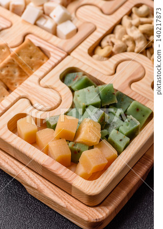 A tray with cubes of mozzarella, and Parmesan cheese, nuts, and crackers. Cheese, crackers, and nuts A tray with cubes of mozzarella, and Parmesan cheese, nuts, and crackers. Cheese, crackers, and nuts 140217873