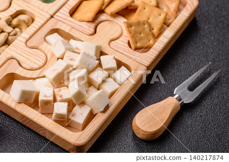 A tray with cubes of mozzarella, and Parmesan cheese, nuts, and crackers. Cheese, crackers, and nuts A tray with cubes of mozzarella, and Parmesan cheese, nuts, and crackers. Cheese, crackers, and nuts 140217874