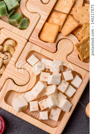 A tray with cubes of mozzarella, and Parmesan cheese, nuts, and crackers. Cheese, crackers, and nuts A tray with cubes of mozzarella, and Parmesan cheese, nuts, and crackers. Cheese, crackers, and nuts 140217875