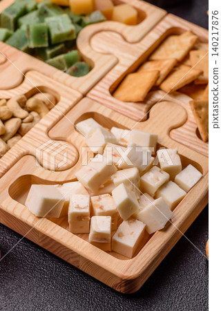 A tray with cubes of mozzarella, and Parmesan cheese, nuts, and crackers. Cheese, crackers, and nuts A tray with cubes of mozzarella, and Parmesan cheese, nuts, and crackers. Cheese, crackers, and nuts 140217876