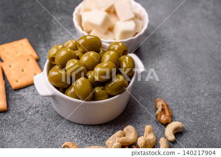 Whole green olives without pits in a bowl as an ingredient for cooking at home. Green olives 140217904