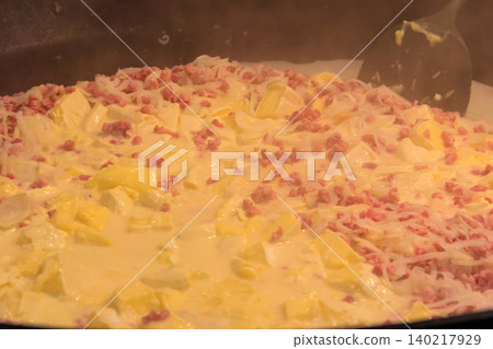 Cooking of  tartiflette, a traditional French dish of scalloped potatoes, bacon and cheese, in big cauldron 140217929