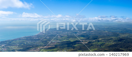 Sweeping mountain panorama revealing the sparkling Mediterranean Sea, Estepona and distant Gibraltar beneath open skies from Sierra Bermeja in Spain. Sweeping mountain panorama revealing the sparkling Mediterranean Sea, Estepona and distant Gibraltar beneath open skies from Sierra Bermeja in Spain. 140217969