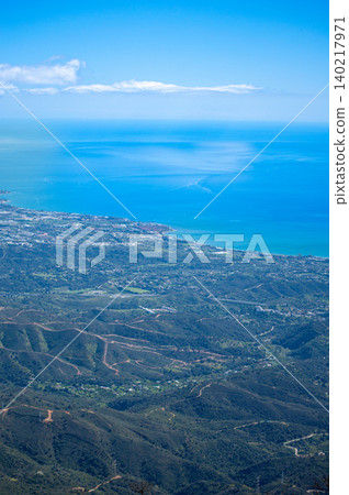 Sweeping mountain panorama revealing the sparkling Mediterranean Sea, Estepona and distant Gibraltar beneath open skies from Sierra Bermeja in Spain. Sweeping mountain panorama revealing the sparkling Mediterranean Sea, Estepona and distant Gibraltar beneath open skies from Sierra Bermeja in Spain. 140217971