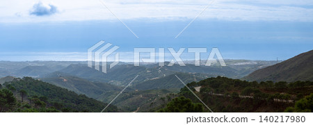 Sweeping mountain panorama revealing the sparkling Mediterranean Sea, Estepona and distant Gibraltar beneath open skies from Sierra Bermeja in Spain. Sweeping mountain panorama revealing the sparkling Mediterranean Sea, Estepona and distant Gibraltar beneath open skies from Sierra Bermeja in Spain. 140217980